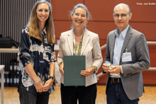 drei Personen stehen nebeneinander