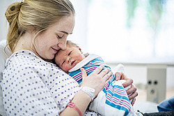 Frau hält neugeborenes Baby im Arm