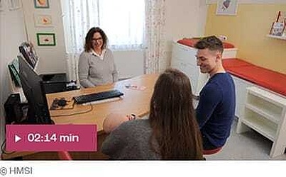 Bildausschnitt aus Video: Junge Eltern mit Baby sitzen am Tisch einer Frau gegenüber