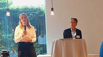 Professorin Dr. Claudia Buß mit Mikrofon, Dr. Dirk Bange am Stehtisch