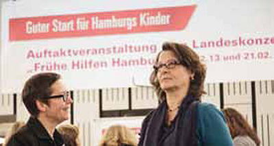 Auftaktveranstaltung Hamburger Landesprogramm Zwei Frauen vor Plakat zur Auftakveranstaltung