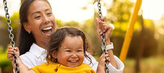 Mutter und Kind sitzen zusammen auf einer Schaukel