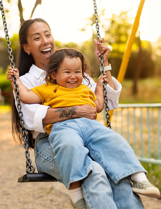 Mutter und Kind sitzen zusammen auf einer Schaukel