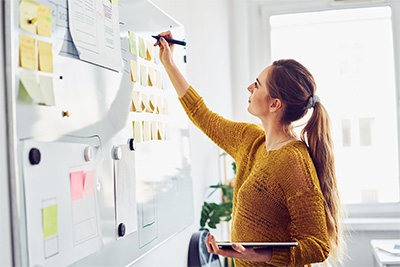 Frau schreibt auf ein Whiteboard