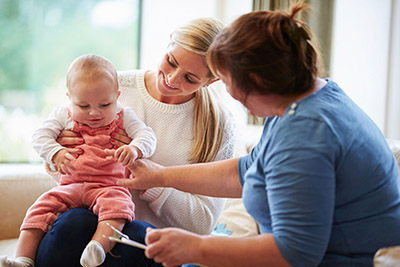 466346839 Hebamme sieht nach Mutter mit Baby auf dem Schoss