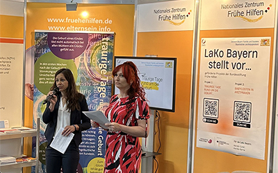 zwei Frauen halten vor einem Messestand einen Vortrag