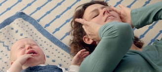 Gestresste Mutter liegt neben schreiendem Baby