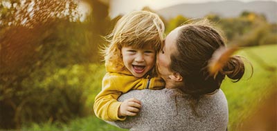 Mutter mit Kind auf dem Arm in der Natur