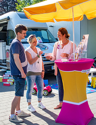 drei Personen an einem Beratungsstand