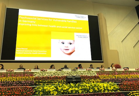 Foto mit Kongress-Teilnehmenden vor Leinwand mit Anzeige des NZFH Vortrags