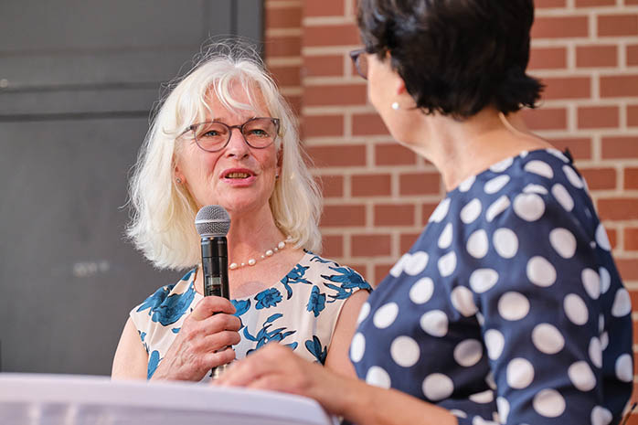 Prof. Dr. Ute Thyen mit Mikrofon in der Hand spricht zu Moderatorin Christiane Poertgen