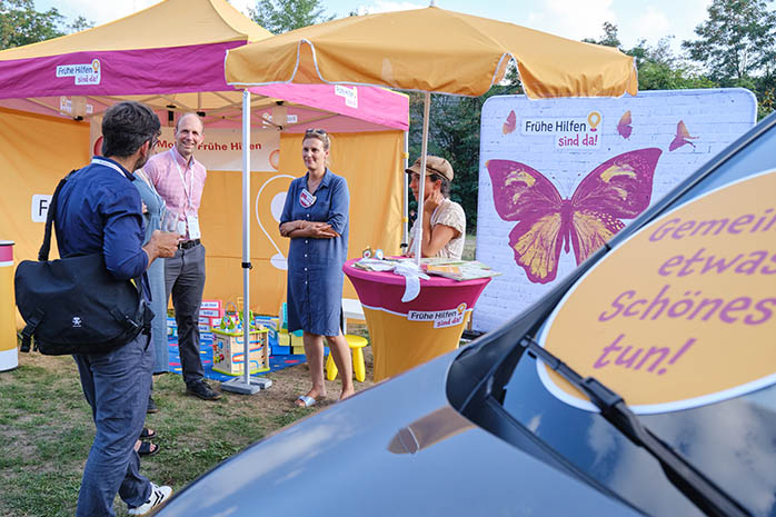 Teilnehmende im Gespräch am Infostand „Frühe Hilfen sind da“