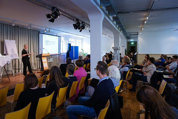 Workshop-Teilnehmende sitzen in Stuhlreihen