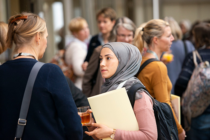 Eine Frau mit Kopftuch spricht mit einer anderen Frau