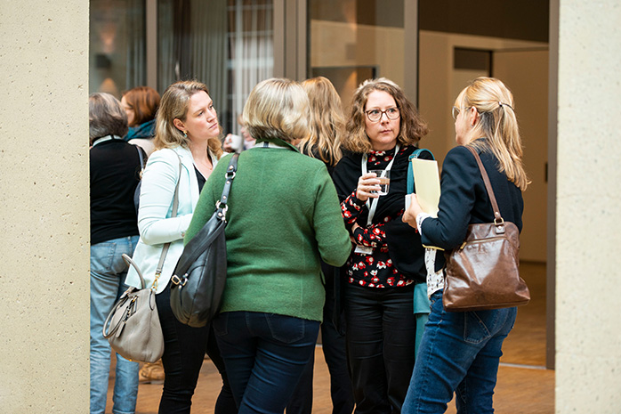 4 Frauen stehen zusammen und tauschen sich aus